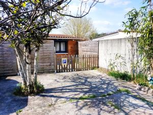 a house with a wooden fence and a driveway at L'instant voyageur in Virsac