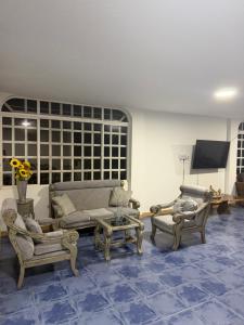 a living room with couches and chairs and a tv at Hotel restaurante hortencia in La Mesa