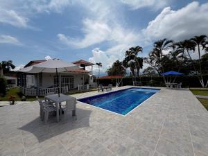a house with a swimming pool with a table and an umbrella at Hotel restaurante hortencia in La Mesa