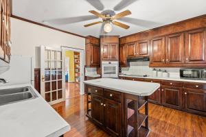 a kitchen with wooden cabinets and a ceiling fan at 1875 Historic Manor, 5 Acres Near Helen & Wineries in Baldwin