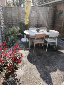 a table and chairs in a backyard with a umbrella at L'instant voyageur in Virsac
