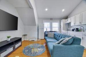 a living room with a blue couch and a kitchen at 2BR Apt Near EWR & NYC • Workspace + Parking in Newark
