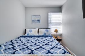 a blue and white bed in a white bedroom at 2BR Apt Near EWR & NYC • Workspace + Parking in Newark