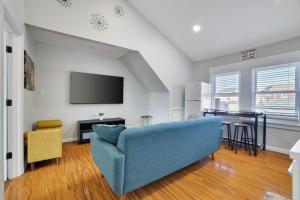 a living room with a blue couch and a table at 2BR Apt Near EWR & NYC • Workspace + Parking in Newark
