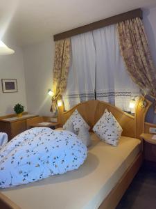 a bedroom with a bed with a blue comforter and pillows at Haus Käfersberg in Naturno