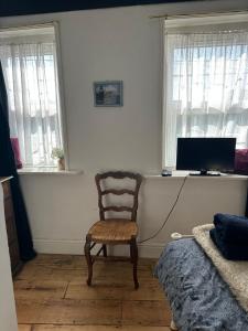 a living room with a chair and a television at The Pepper Pot in Lympstone