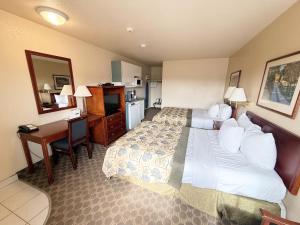 a hotel room with a large bed and a desk at Travelodge by Wyndham Drumheller AB in Drumheller
