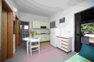 a kitchen with a table and a white refrigerator at Villaggio Turistico Grotta dell'Acqua in Peschici