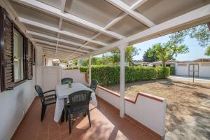 a patio with a table and chairs on a porch at Villaggio Turistico Grotta dell'Acqua in Peschici