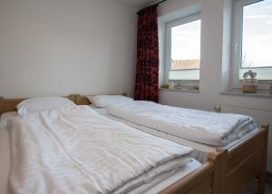 two unmade beds in a room with two windows at Apartment Im Hohlen Seifen 10-H in Winterberg