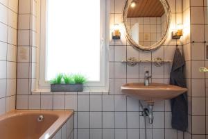 a bathroom with a sink and a tub and a mirror at Zur Waldschmiede in Kakenstorf