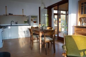 a kitchen with a wooden table and chairs at Zur Waldschmiede in Kakenstorf +10 photos