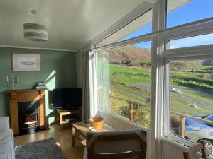 a living room with a large window and a television at 49 Erw Porthor in Tywyn