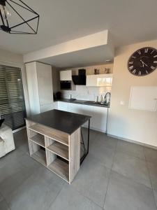 a kitchen with a table and a clock on the wall at Appartement 2 pièces in Fréjus
