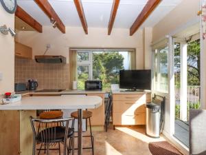 a kitchen with a table and chairs and a window at Sea Glimpse in Dawlish
