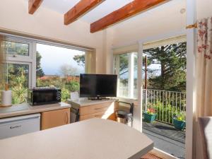 a kitchen with a large window and a tv at Sea Glimpse in Dawlish