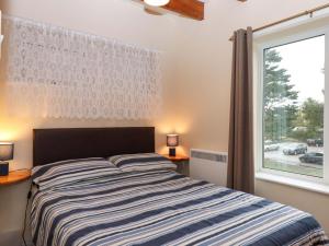 a bedroom with a bed and a large window at Sea Glimpse in Dawlish