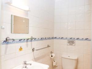 a bathroom with a toilet and a sink and a mirror at Sea Glimpse in Dawlish +30 photos