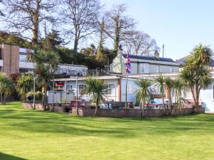a building with palm trees in front of it at Sea Glimpse in Dawlish