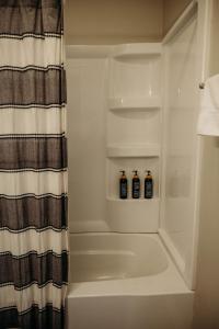 two bottles ofiki sit in the corner of a bathroom at Freetown Blueplex Downtown Lafayette in Lafayette