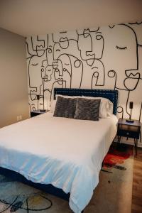 a bedroom with a white bed with a black and white wall at Freetown Blueplex Downtown Lafayette in Lafayette