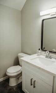 a bathroom with a toilet and a sink and a mirror at Freetown Blueplex Downtown Lafayette in Lafayette +14 photos