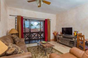 a living room with a couch and a flat screen tv at Unique Colorful Condo on 3rd Floor Pinacate 321 in Puerto Peñasco