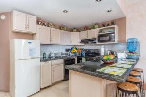 a kitchen with white cabinets and a white refrigerator at Unique Colorful Condo on 3rd Floor Pinacate 321 in Puerto Peñasco
