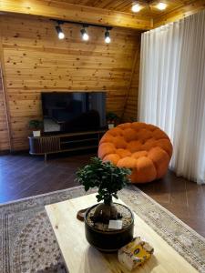 a living room with a large chair and a table at أكواخ غصُن عجلون in Ajloun