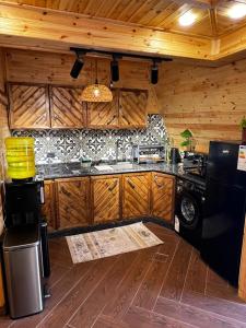 a kitchen with wooden cabinets and a stove at أكواخ غصُن عجلون in Ajloun