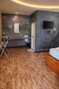 a room with a bed and a bathroom with a wooden floor at อ่าวนางอิงผารีสอร์ท Aingpha resort in Ao Nang 