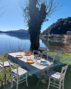 a table with chairs and a view of a lake at Alma Capodimonte Lake chalet in Capodimonte
