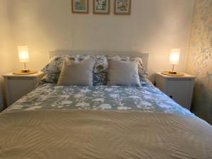 a bedroom with a bed with two lamps on both sides at 49 Erw Porthor in Tywyn
