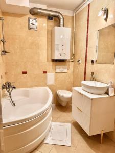 a bathroom with a tub and a toilet and a sink at Plac 14- Apartamenty i pokoje w centrum in Świnoujście +106 photos