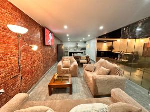 a living room with two couches and a brick wall at Modern house with pool in Ica in Ica