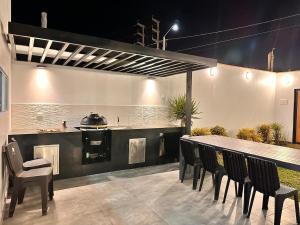 a patio with a table and chairs and a grill at Modern house with pool in Ica in Ica