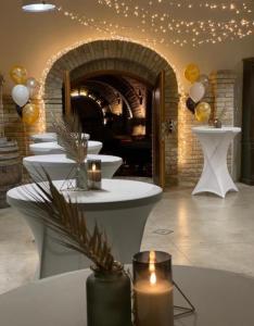 a row of tables with candles in a room at Vass-Villa Vendégház in Szekszárd +58 photos