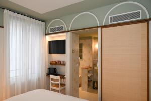a bedroom with a bed and a closet with a mirror at Le Petit Hôtel in Saint-Jean-de-Luz