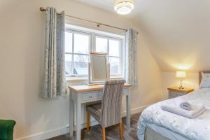 a bedroom with a desk with a mirror and a bed at 3 Bed in Lairg oc-96459 in Achfary