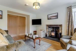 a living room with a couch and a fireplace at 3 Bed in Lairg oc-96459 in Achfary