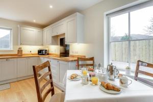 a white kitchen with a table with food on it at 3 Bed in Lairg oc-96459 in Achfary