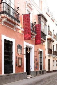 a building with red decorations on the side of a street at Casa Inquieta Hotel Boutique in Seville