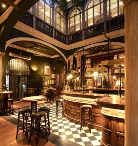 a bar with tables and stools in a restaurant at Casa Inquieta Hotel Boutique in Seville