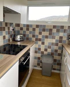 a small kitchen with a sink and a window at 49 Erw Porthor in Tywyn +2 photos
