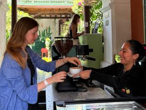 a woman is getting a cup of coffee in a coffee shop at Tropicana La Catedral in Antigua Guatemala