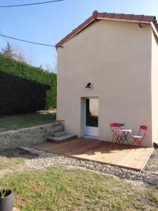 a patio with a table and chairs next to a building at La maisonnette du Chambon in Monistrol-sur-Loire