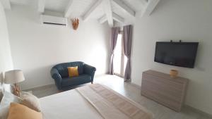 a bedroom with a tv and a chair in a room at Villa 21 in Budoni