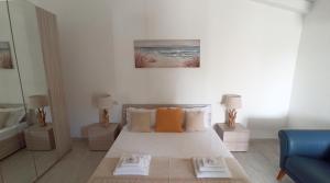 a white bedroom with a bed and a blue couch at Villa 21 in Budoni +37 photos
