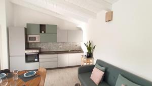 a kitchen and living room with a couch and a table at Villa 21 in Budoni