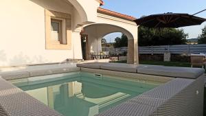 a swimming pool with an umbrella next to a house at Villa 21 in Budoni